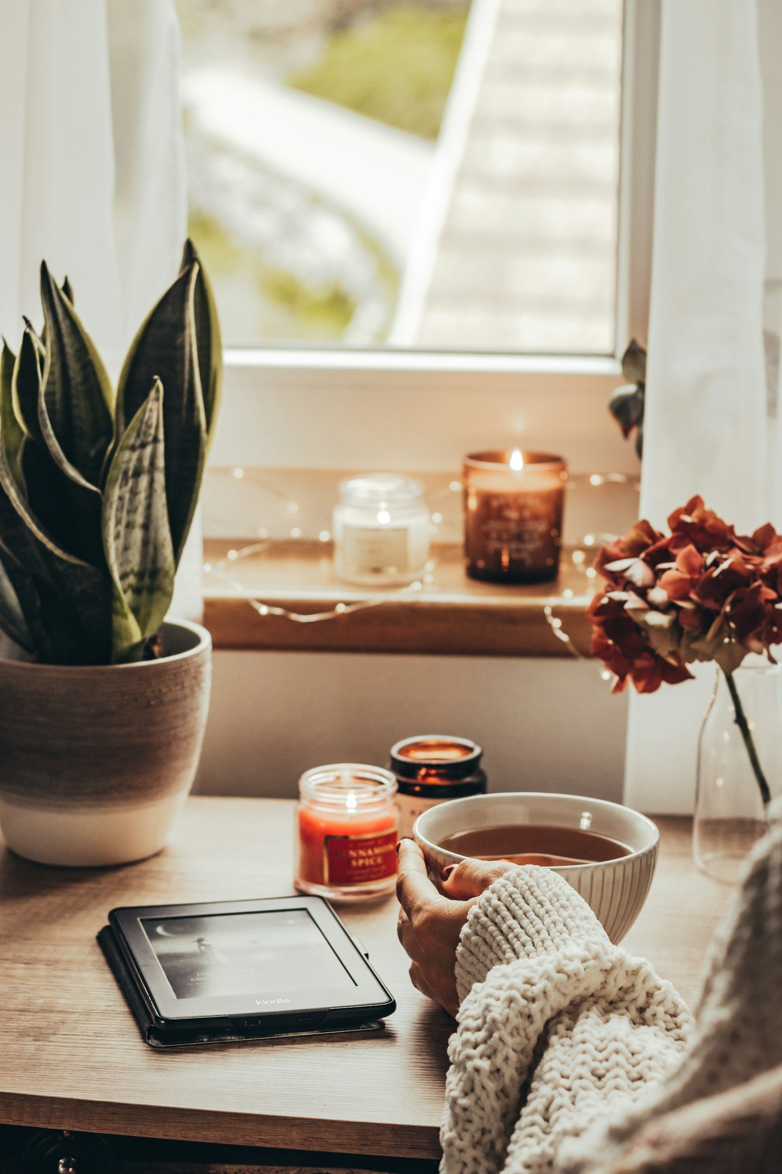 A cosy breakfast table with candles and tea